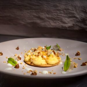 Tartaleta de lima y limón, crumble de avellanas tostadas y chocolate blanco, toffe de vainilla salado y crema de queso